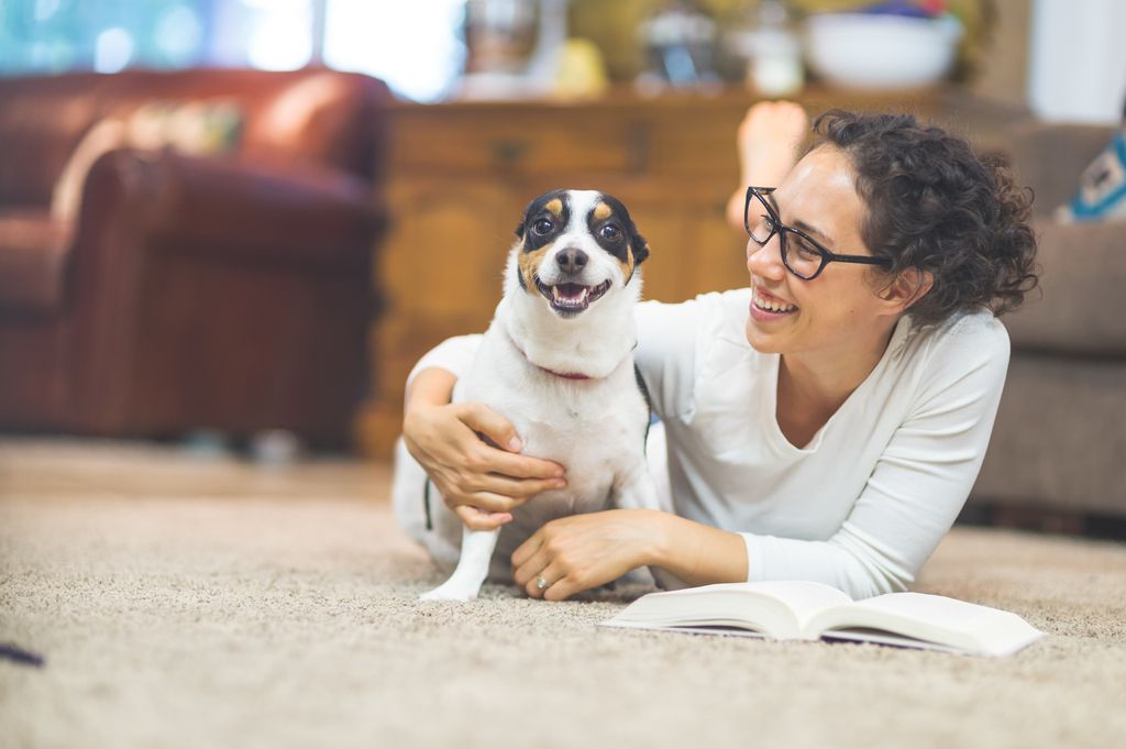 femme allongé sur le sol avec son chien à côté d'elle