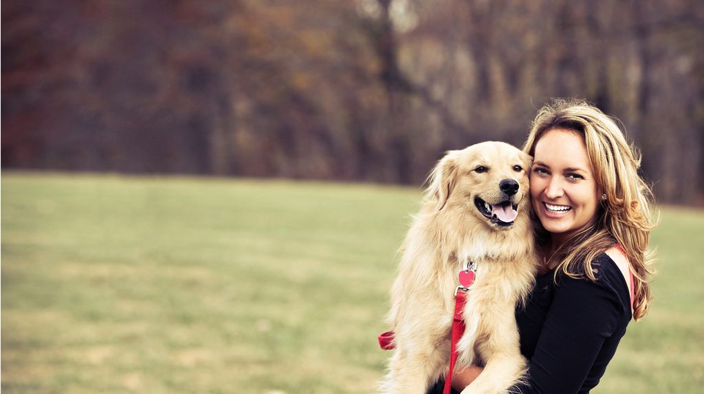 femme qui tient un chien dans ses bras