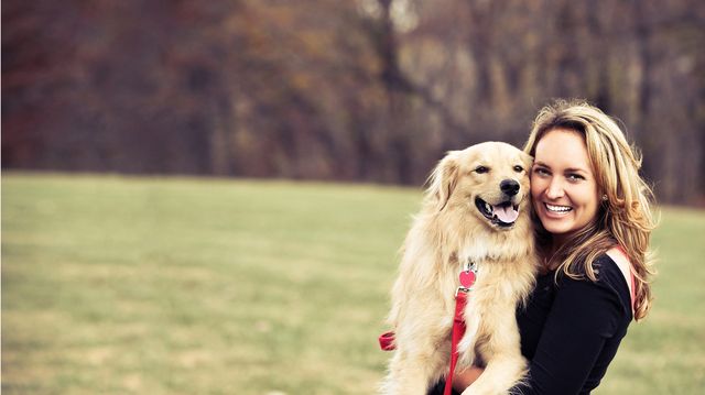 femme qui tient un chien dans ses bras