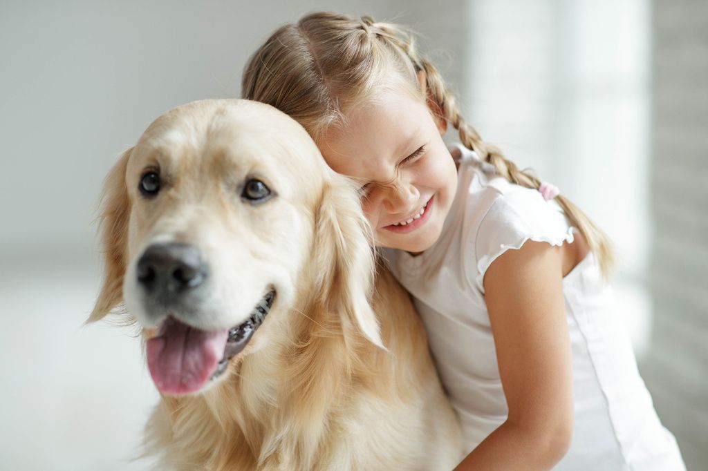 petite fille qui fait un câlin à un chien