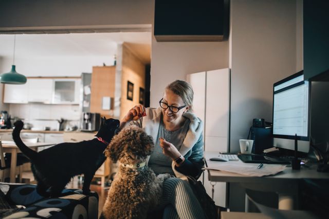 femme qui nourrit un chat et un chien