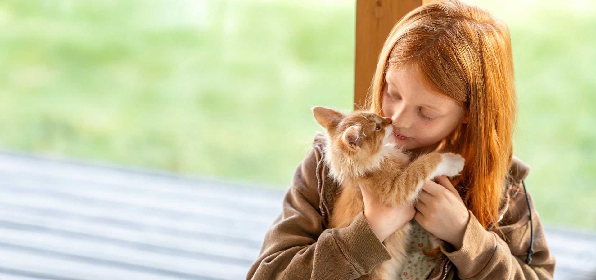 Une petite fille câline son chaton.