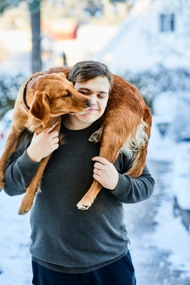 Chien porté sur le dos d'un homme debout