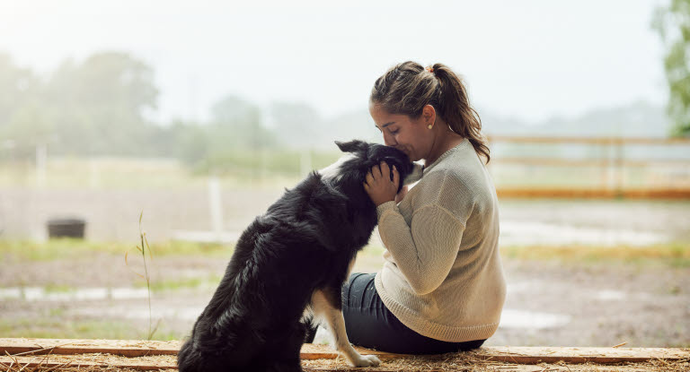 une femme fait un bisou à son chien