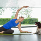 Un femme fait du yoga-fitness avec son chien